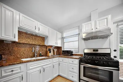 a white kitchen with white cabinets and a stove at Stylish LAX Area 2BR 1BA by LMU, SoFi Stadium & Coastal Beaches in Los Angeles