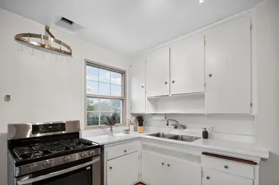 a white kitchen with a stove and a sink at Cozy Comfort Stylish 2BR 1BA near LAX, LMU, SoFi Stadium & Beaches in Los Angeles