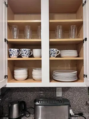 a kitchen cabinet filled with plates and cups and dishes at Bright & Spacious 5BR Modern Vacation Home - Near Disneyland & Beaches in Orange