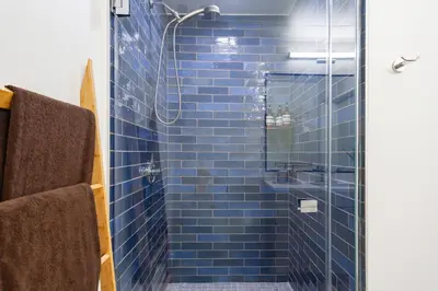 a blue tiled shower with a glass door at Boutique Mini 1 BD Residence in Los Angeles