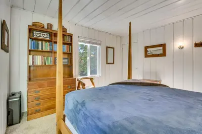 a bedroom with a bed and a book shelf at Private Dock on Lake Arrowhead! Cozy Mtn Cabin in Lake Arrowhead