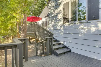 a house with a staircase with a red umbrella at Private Dock on Lake Arrowhead! Cozy Mtn Cabin in Lake Arrowhead