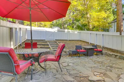 a patio with a table and chairs and an umbrella at Private Dock on Lake Arrowhead! Cozy Mtn Cabin in Lake Arrowhead