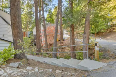 a set of concrete steps in front of trees at Private Dock on Lake Arrowhead! Cozy Mtn Cabin in Lake Arrowhead