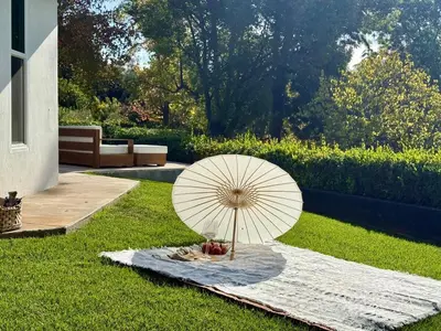 a umbrella sitting on a blanket in the grass at The Chapel - Luxury Historic Ojai Villa in Ojai