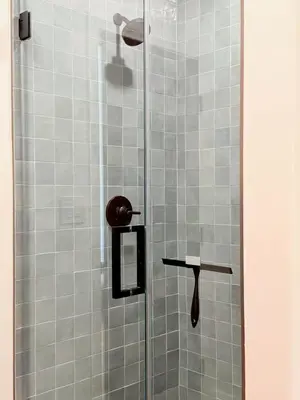 a shower stall with a glass door with a wooden handle at The Chapel - Luxury Historic Ojai Villa in Ojai
