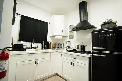 a kitchen with white cabinets and a black refrigerator at Modern Guesthouse ADU Sanctuary in San Bernardino