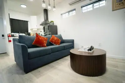 a living room with a blue couch and a table at Modern Guesthouse ADU Sanctuary in San Bernardino