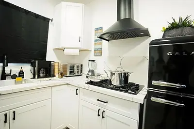 a kitchen with white cabinets and a black stove top oven at Modern Guesthouse ADU Sanctuary in San Bernardino