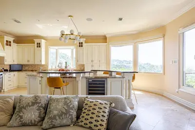 a living room with a couch and a kitchen at Mansion in the hills near Universal Studios!