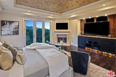 a bedroom with a large bed and a fireplace at Mansion in the hills near Universal Studios!