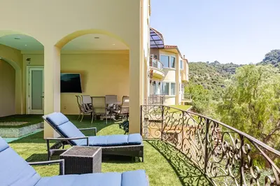 a balcony of a house with chairs and a television at Mansion in the hills near Universal Studios!