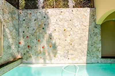 a swimming pool with a stone wall and a swimming pool at Mansion in the hills near Universal Studios!