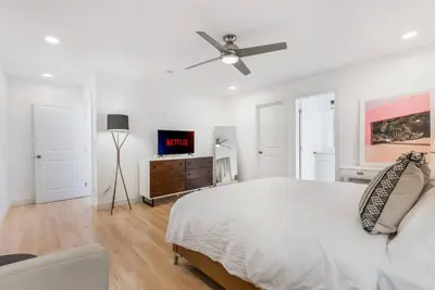 a white bedroom with a bed and a ceiling fan at Minimalist Serene Home near Rose Bowl Stadium in Pasadena