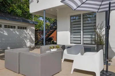 a patio with a table and chairs and an umbrella at Minimalist Serene Home near Rose Bowl Stadium in Pasadena