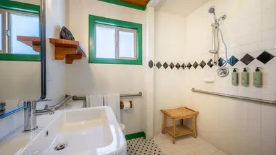a white bathroom with a sink and a shower at Arkouda Stays in Big Bear Lake