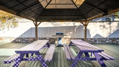 a picnic table and benches on a deck at Arkouda Stays in Big Bear Lake