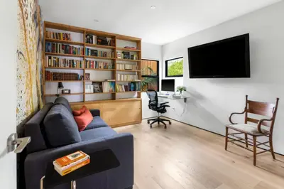 a living room with a blue couch and a book shelf at Brooks Beach House Your Venice Escape in Los Angeles