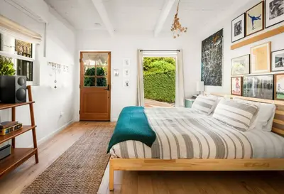a bedroom with a large bed and a door at Laurel Canyon Hideaway Fireplace and Sauna in Los Angeles