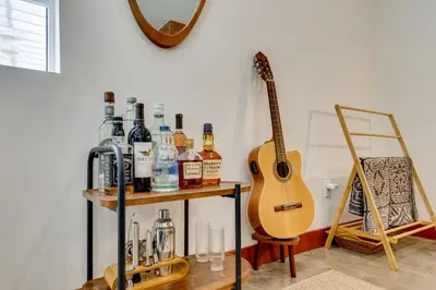 a guitar on a shelf next to a table with bottles at 3 Mi to Old Pasadena Cozy Couples Studio with Pool in Pasadena