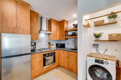 a kitchen with wooden cabinets and a washer and dryer at 3 Mi to Old Pasadena Cozy Couples Studio with Pool in Pasadena