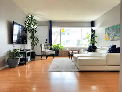 a living room with a white couch and a tv at Proper Stays at Melrose - West Hollywood Premium E suite in Los Angeles