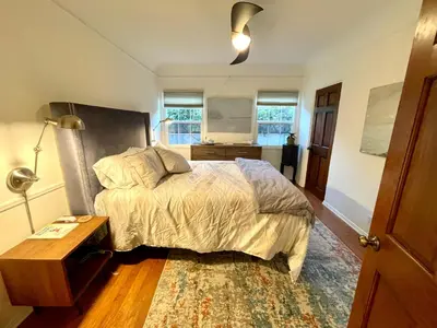 a bedroom with a bed and a table and windows at Culver Adjacent Spanish in Los Angeles