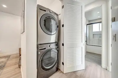 a washer and dryer in a white laundry room at Modern 3BR with King Bed, Gated Pool and BBQ Oasis in West Valley Area Heliport