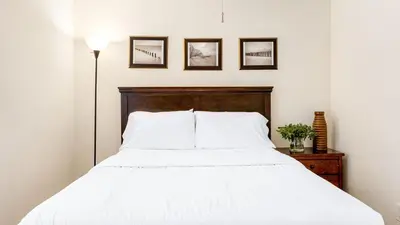 a bedroom with a white bed with a wooden headboard at Sunny Venice Beach Home with Open Living Walkability to Abbot Kinney Venice Drift by AvantStay in Los Angeles