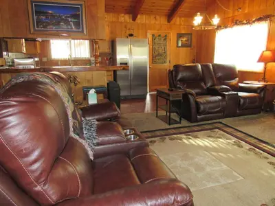 a living room with a leather couch and a refrigerator at M & M Sweet Retreat in Big Bear Lake