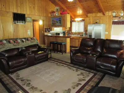 a living room with two leather couches and a kitchen at M & M Sweet Retreat in Big Bear Lake