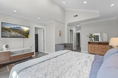 a bedroom with a large bed and a tv on the wall at Wonderful Home Near Claremont! With Amazing Backyard! in Pomona