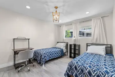 a bedroom with two beds and a desk and a chair at Wonderful Home Near Claremont! With Amazing Backyard! in Pomona