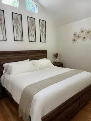 a bedroom with a large bed and four windows at Woodsy Chic Family-Friendly Spacious Getaway in Lake Arrowhead