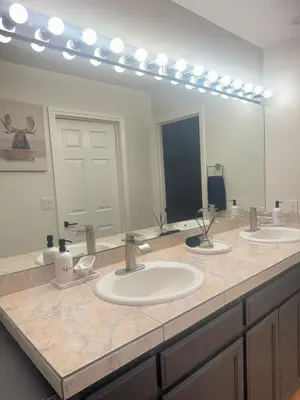 a bathroom with three sinks and a large mirror at Woodsy Chic Family-Friendly Spacious Getaway in Lake Arrowhead
