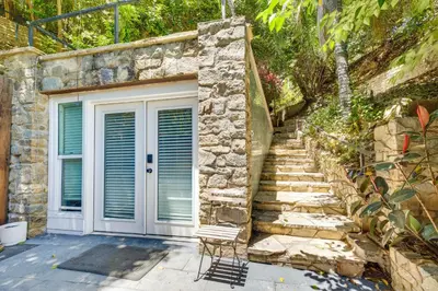 a stone building with a white door and stairs at Hillside Home with Outdoor Oasis and Pool in Sherman Oaks