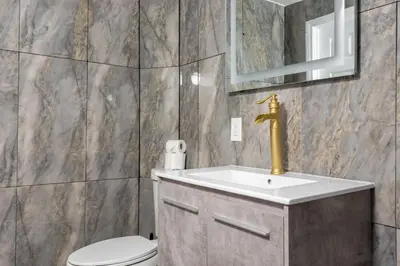 a bathroom with a sink and a toilet and a mirror at Hillside Home with Outdoor Oasis and Pool in Sherman Oaks
