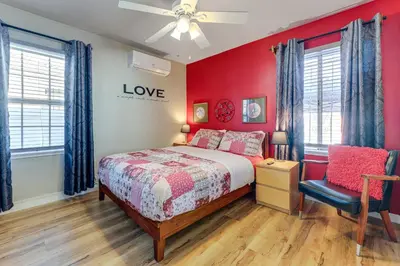 a bedroom with red walls and a bed and a chair at Stylish Home Near SoFi Stadium, LAX and Long Beach in Compton