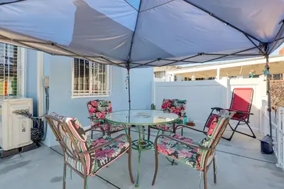 a table and chairs on a patio with an umbrella at Stylish Home Near SoFi Stadium, LAX and Long Beach in Compton