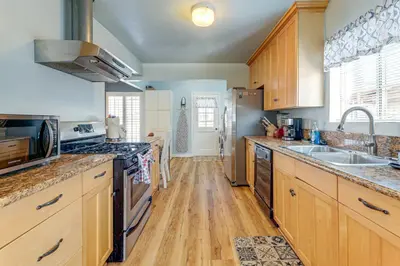 a large kitchen with wooden cabinets and stainless steel appliances at Stylish Home Near SoFi Stadium, LAX and Long Beach in Compton