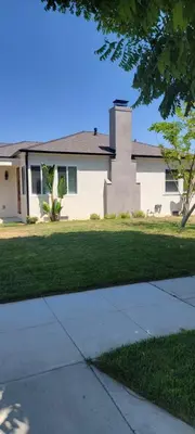 a white house with a tree in front of it at 2 bedroom Cozy house in heart of Burbank in Burbank