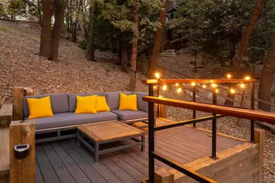a couch on a deck with lights and a table at Lumiere Cabin in Lake Arrowhead