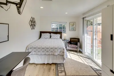 a bedroom with a bed and a desk and windows at Work and Play! Extended-Stay Studio in Simi Valley in Simi Valley