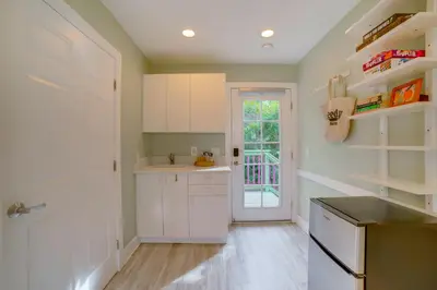 a kitchen with white cabinets and a door at Walk to Festival of Lights Cozy Couples Retreat in Riverside