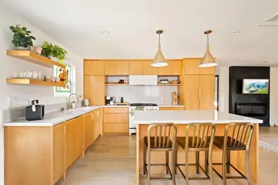 a kitchen with wooden cabinets and a table and chairs at LA Oasis with Private Yard 10 min to Beach LAX 405 in Los Angeles