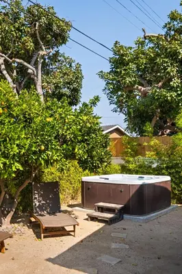 a hot tub in a yard next to two trees at LA Oasis with Private Yard 10 min to Beach LAX 405 in Los Angeles