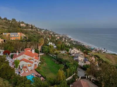 an aerial view of a house on a hill next to the ocean at Villa Costera in Malibu Beach
