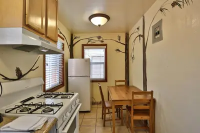 a kitchen with a stove and a table and a refrigerator at Bear Creek Resort in Big Bear Lake