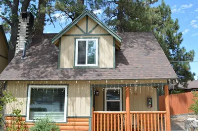 a small house with a fence in front of it at Bear Creek Resort in Big Bear Lake