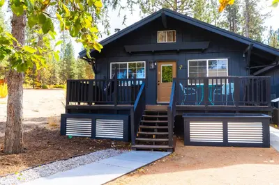 a black tiny house with stairs leading to the door at Sessions Retreat & Hotel in Big Bear Lake